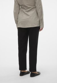 Striped long-sleeve shirt in light gray and white, paired with black pants. Flat black shoes with rounded toes complete the outfit.