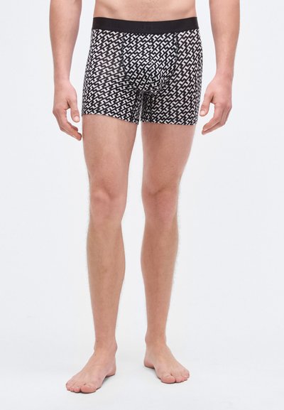 Cuecas boxer masculinas padrão em preto e branco com design ajustado e cintura elástica, apresentando uma estampa geométrica em toda a peça.