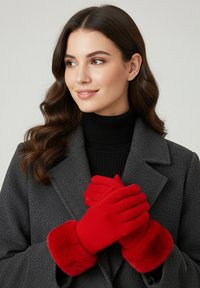 Rote Handschuhe mit einem weichen Fellbesatz, gefertigt aus einem strukturierten Strickmaterial, getragen über einem schwarzen Rollkragenpullover und einem grauen Mantel.