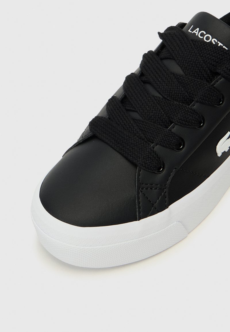 Sneaker in pelle nera con puntale arrotondato, superficie testurizzata, lacci neri e suola in gomma bianca. Presenta un accento logo bianco.