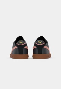 Sneaker nere e rosa con finitura testurizzata, suola in gomma e un leggero marchio sul retro. Presentano un collare sagomato e un design a due materiali.