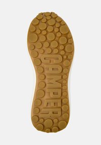 Suola di scarpa in gomma con un motivo testurizzato a cerchi di colore beige con la scritta "CAMPER" impresso. La taglia 38 è indicata sulla superficie.