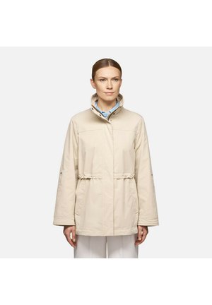 Chaqueta beige con un cuello alto, cintura elástica y mangas largas. Fabricada con una tela suave, cuenta con bolsillos laterales y un ajuste holgado.