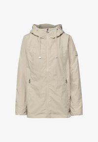 Chaqueta con capucha color beige claro, con cremallera frontal, cordones ajustables, bolsillos laterales con cremallera y parche de logo sutil en la manga izquierda.