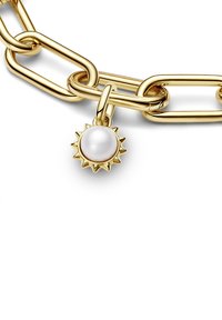 Catena in metallo dorato, con anelli ovali e un charm a forma di sole con una perla centrale. Texture liscia con finitura lucida.