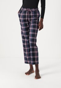 Pantalons à carreaux navy avec des motifs en grille rose et blanche, fabriqués en tissu doux, dotés d'une taille élastique avec cordon de serrage et de poches latérales.