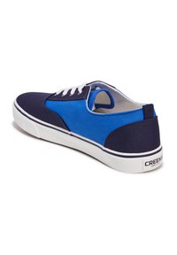 Sneaker in tela blu e navy con lacci bianchi, suola bianca e logo sul tallone. Presenta un design a basso profilo e pannelli in tessuto a contrasto.