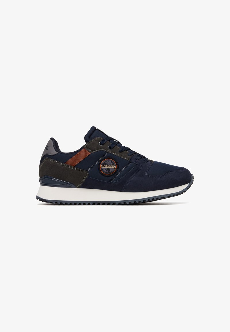 Sneaker blu navy con materiali in suede e tessuto, caratterizzato da accenti marroni, un patch rotondo con logo e una suola in gomma bianca con trazione.