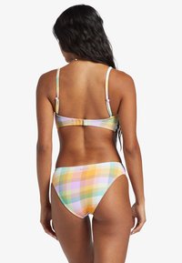 Costume da bagno a bikini a quadri multicolori, con tonalità pastello che includono rosa, arancione, verde e blu. Spalline regolabili e chiusura con gancio sul retro.