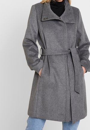 Manteau en chevrons gris avec un large col, une taille ceinturée et des poches plaquées. Le tissu a une finition texturée et présente une silhouette ajustée.