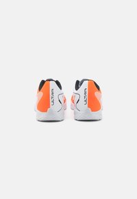 White athletic shoes with orange accents and textured surfaces, featuring a cushioned heel, lightweight design, and rubber sole.