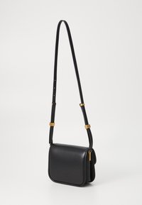 Black leather shoulder bag with minimalistic design, rectangular shape, adjustable strap, and gold-tone hardware accents.