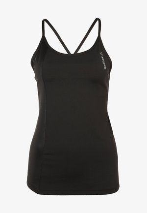Femme marchant avec un débardeur noir Reebok, un short à motifs colorés et des chaussures de sport noires sur un fond uni.
