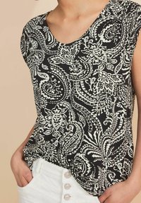 Černobílý top s paisley vzorem, krátké rukávy, kulatý výstřih, měkká tkanina a mírně volný střih. Nosit s bílými kalhotami.