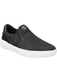 Black slip-on shoe with suede and leather materials, white cushioned sole, elastic side panels, and logo detail on the tongue.