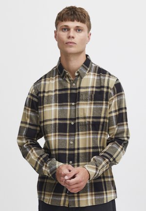 Camicia a maniche lunghe a quadri nei toni beige, nero e grigio, con chiusura a bottoni frontale, tasca sul petto e un tessuto morbido e texturizzato.