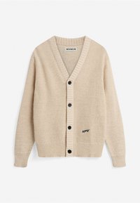 Cardigan beige tricoté avec col en V, boutons noirs sur le devant, poignets et ourlet côtelés, et petit texte noir brodé sur l'ourlet avant.