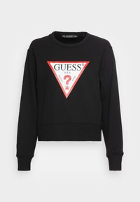 Sudadera recortada negra con un cuello redondo, que presenta un gráfico de logo triangular rojo con texto y un signo de interrogación en el centro.