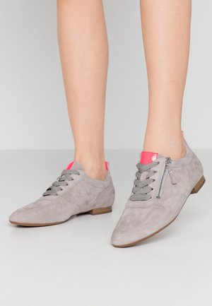 Grå ruskindssko med lav hæl, der har lyserøde detaljer bagpå, grå snørebånd og en sidelukning med lynlås. Glat overflade, sporty design.