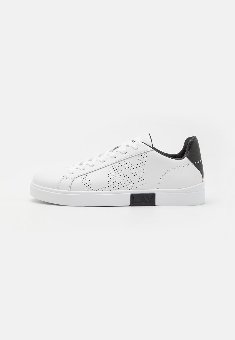 Tenis alb din piele cu un design perforat, accent negru pe călcâi și talpă intermediară. Dispune de vârf rotund și sistem de șireturi cu șase gauri.
