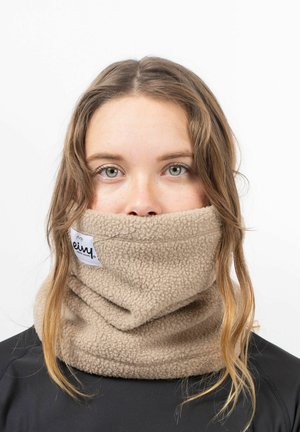 Gaiter en polaire beige avec une texture douce, portant une étiquette avec le nom de la marque. Porté autour du cou, couvrant une partie du bas du visage.