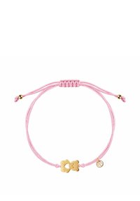 Różowa pleciona bransoletka z złotym charms w kształcie misia i małą okrągłą zawieszką. Posiada suwak z regulacją rozmiaru. Gładka faktura.