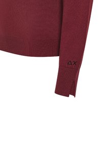 Maglione a maglia bordò con polsini e orlo a coste, fessure laterali per il comfort e un dettaglio del logo nero sulla manica.