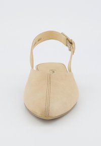 Béžová semišová slingback obuv s kulatou špičkou, která má příčku s přezkou a jemným steh za přední částí. Plná podrážka.