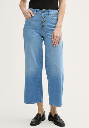 Světlomodré džínové culottes s vysokým pasem, které mají zapínání na knoflíky se čtyřmi knoflíky. Dokončeny rovnou siluetou a zkrácenou délkou.