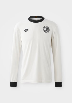 White long-sleeve soccer jersey with a ribbed texture, black collar and cuffs, featuring black Adidas logo and circular graphic emblem.