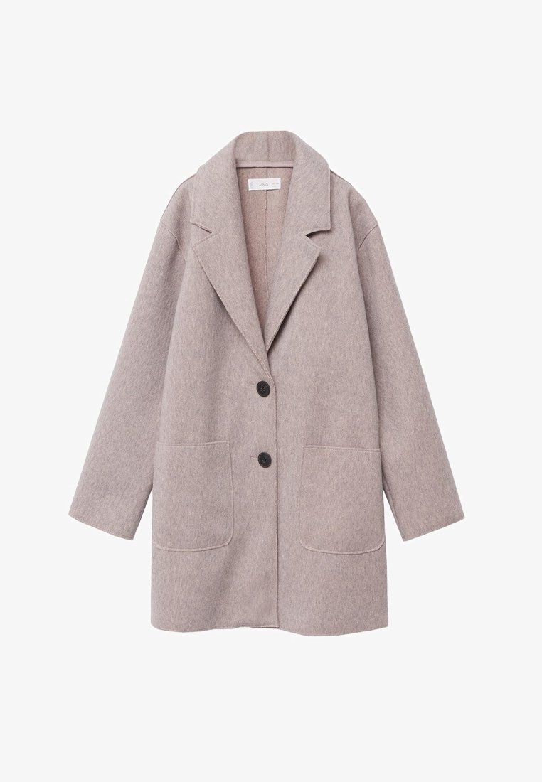 Jasnobeżowy, oversize płaszcz wykonany z miękkiej tkaniny, z kołnierzem z wcięciem, dwoma przednimi kieszeniami i dwoma czarnymi guzikami z przodu.