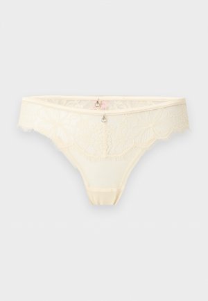 Cream lace bikini-style underwear with floral patterns and two small silver decorative charms at the waistband center.