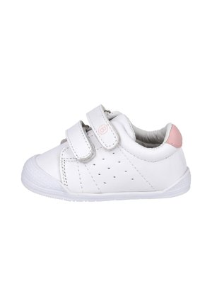 Zapatilla blanca para niño pequeño con dos tiras de Velcro, lado perforado, puntera texturizada y detalle rosa en el talón, vista desde el lado derecho.