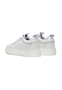 Baskets blanches en cuir avec une texture lisse, à bout arrondi et à profil bas. Présentent des lacets plats et un discret onglet à l'arrière.