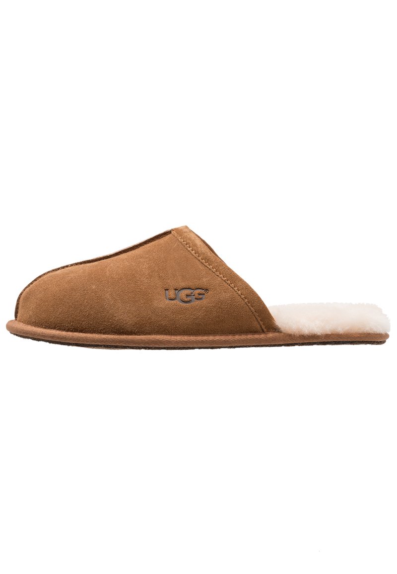 Schwarze Wildlederschlappe mit einem weißen, flauschigen Innenfutter, offenes Rückendesign und UGG-Logo an der Seite. Weiche Textur und abgerundete Form.
