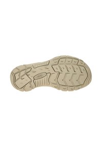 Rubber outsole with a textured beige surface, featuring a multi-directional tread pattern and raised accents for traction and stability.