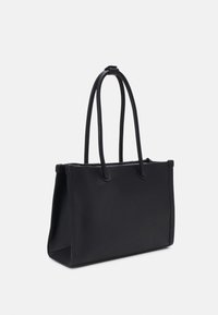 Sac à main rectangulaire noir avec deux longues anses fines et un design structuré à ouverture supérieure sur un fond uni.