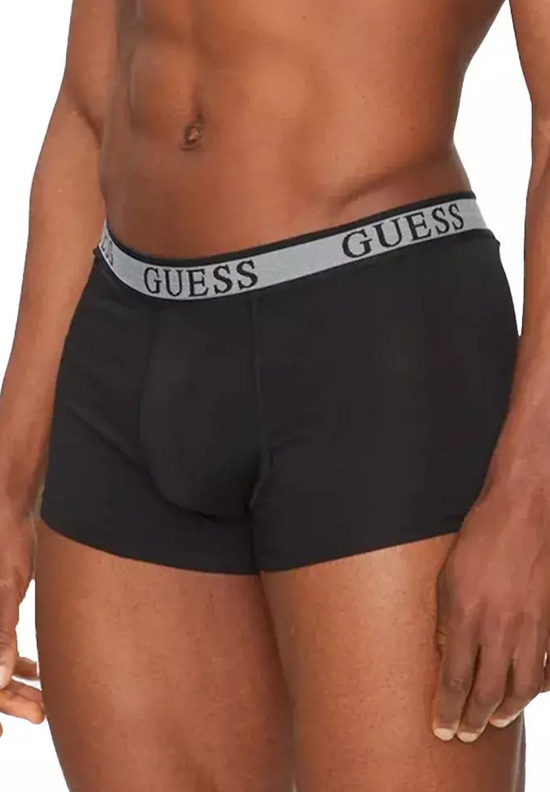 Boxers noirs avec une ceinture grise arborant le logo "GUESS". Fabriqués en tissu doux, ajustement confortable, avec une poche profilée pour le soutien.