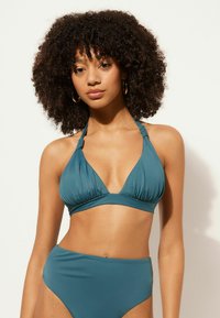 Teal bikinitopp med halterneck och veckad detalj, samt högmidjade trosor. Slät textur, minimalistisk design.