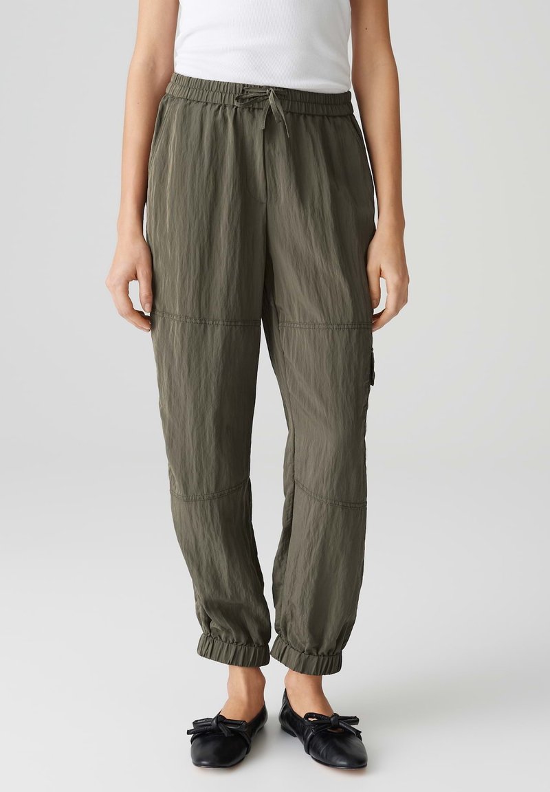 Lichte, olijfgroene joggers met een elastische tailleband, geribbelde manchetten en zichtbare naaddetails voor extra textuur.