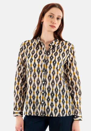 Camicia a maniche lunghe con bottoni in tessuto leggero, caratterizzata da un motivo geometrico nei toni del nero, bianco e giallo, con colletto.