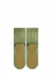 Chaussettes vertes avec des grips en caoutchouc orange texturé et antidérapants sur les semelles. Tissu doux, longueur mi-mollet et haut côtelé.