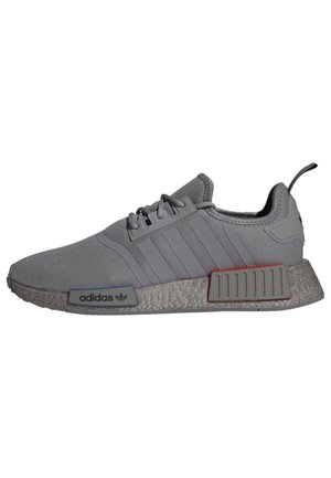 Grauer Adidas-Sneaker mit Mesh-Gewebe, drei seitlichen Streifen, strukturierter Sohle, Schnürverschluss und gebrandeten Sohlenplugs in Blau und Rot.
