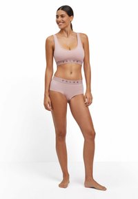 Helles pinkes Sport-BH und passende hochgeschnittene Slips mit elastischem FALKE-Logo-Band. Glattes Material, taillierte Passform, minimale Nähte.