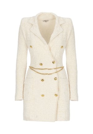 Abito blazer doppiopetto color crema con bottoni dorati e una delicata cintura a catena dorata in vita.