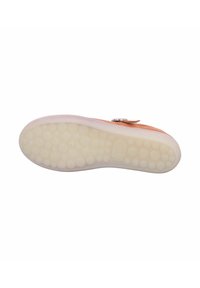 Shoe sole with a textured, light-colored, rubber base featuring raised round dots and a smooth, slightly elevated edge.