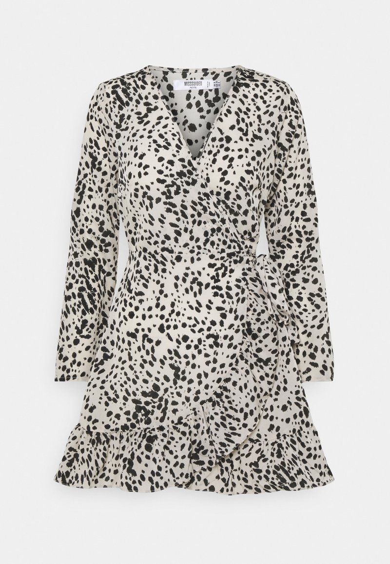 Robe longue à manches longues style portefeuille avec motif taches noir et blanc et ourlet à volants, nouée à la taille sur fond uni.