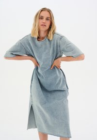 Hele sinine teksakleid, millel on lühikesed varrukad, ümmargune kaelus, küljetaskud ja toores serv. Omab põlvepikkust lõiget ja vabamat istuvust.