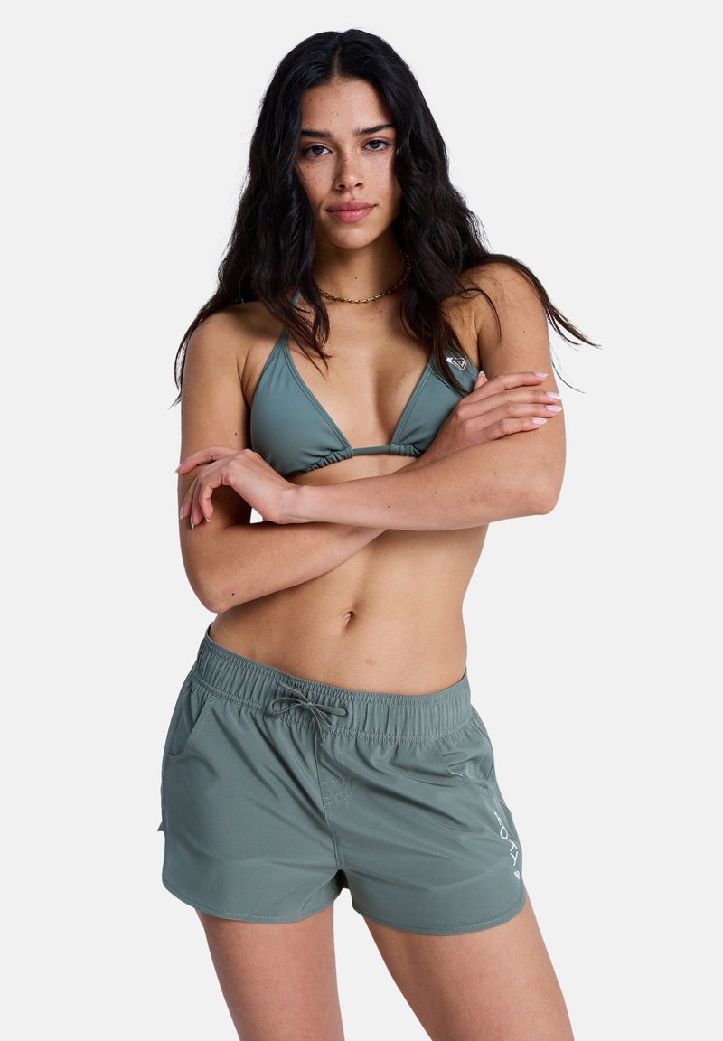 Ensemble de maillot de bain vert composé d'un haut bikini à bonnets triangulaires et bretelles réglables, assorti à un short à taille élastique.