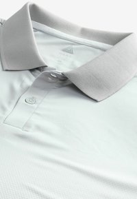 Hellgraues Poloshirt mit strukturiertem Kragen, Drei-Knopf-Leiste und glattem Stoff mit subtilen geometrischen Mustern.